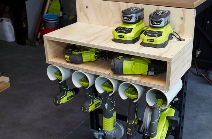 A storage unit with timber shelving and PVC pipes used to store electric tools and batteries