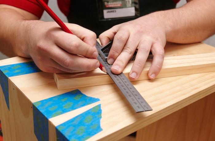 Person marking up a piece of timber with pencil.