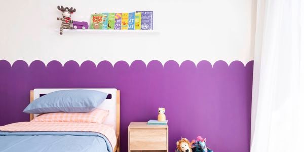 A playful purple scalloped wall feature creates a fun backdrop in a kids bedroom. 