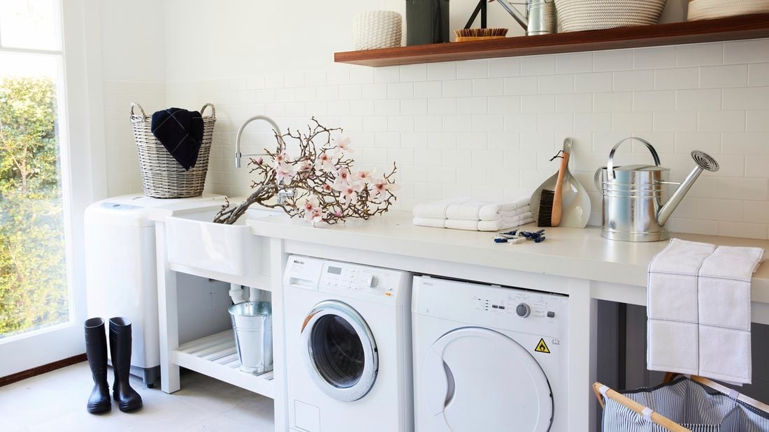 Laundry with washing machine, dryer, watering can and gumboots