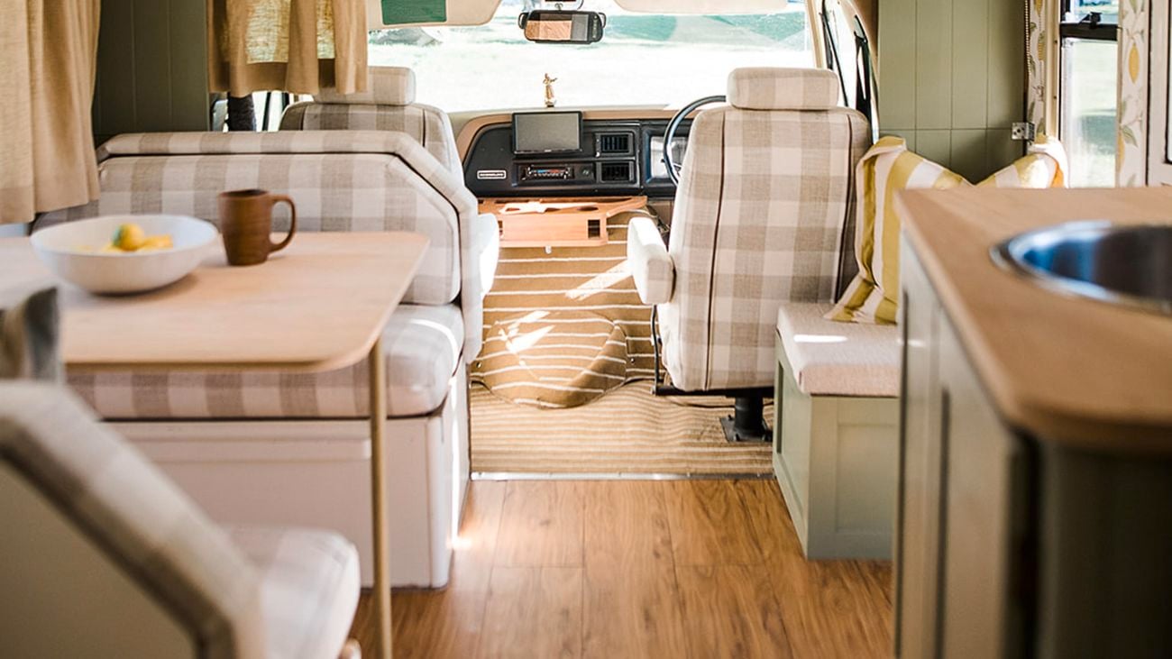The interior of a custom RV, decorated in green, plaid and timber.