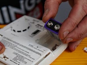 Close-up of someone using energizer battery in a smoke alarm