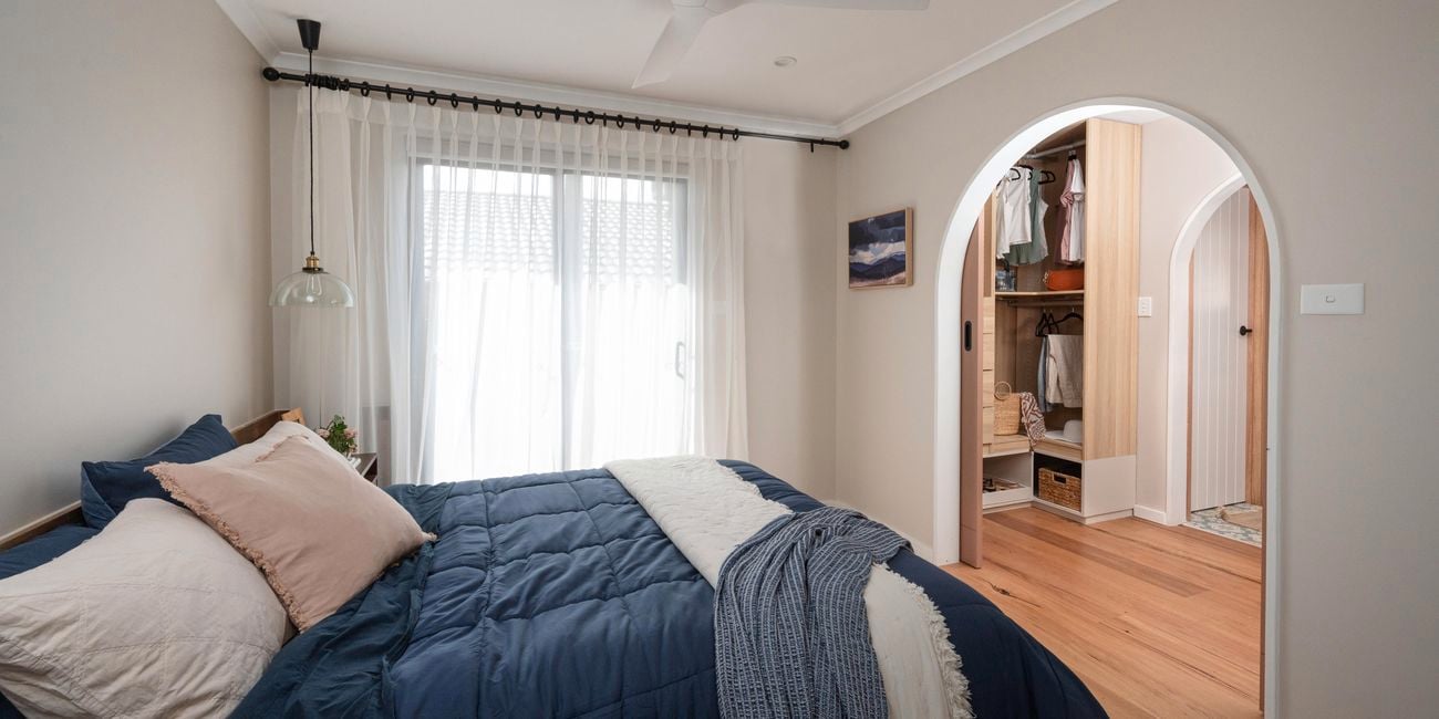 Bedroom with bed in it, a ceiling fan and a picture on the wall