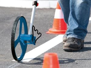 A wheel pedometer being used to measure distance