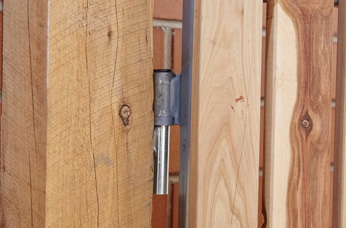 Close-up of gate hinge attached to a post
