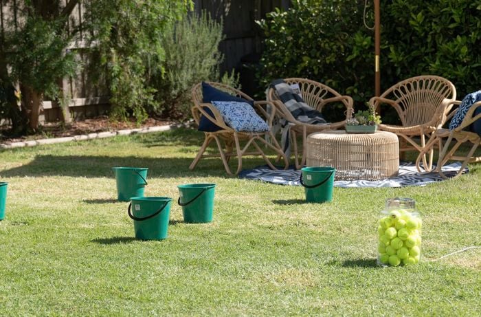Buckets spread out and a bucket full of tennis balls.