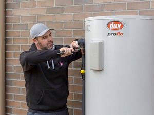 man fixing an electric water heater