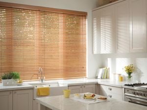 Custom Roman Blinds hanging in a kitchen interior.