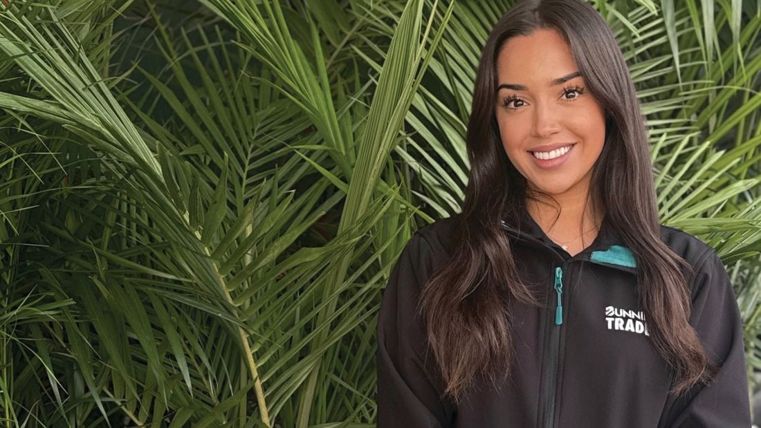 Bunnings Trade Landscape Specialist Vic stands in a black work shirt behind a large plant.