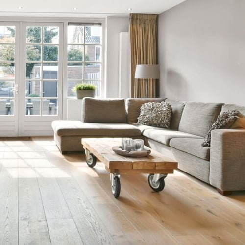 Living room with couch and timber coffee table  with large wheels.