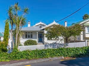 White timber house  with white picket fence
