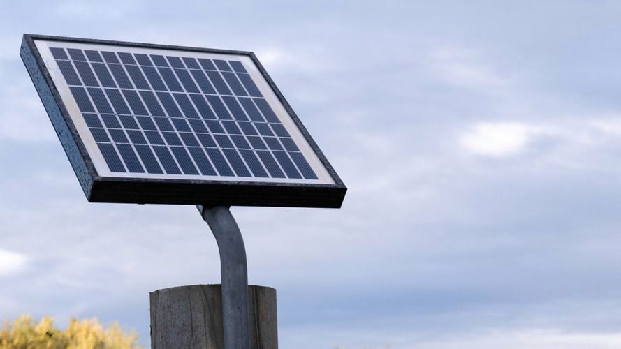 KT solar panel mounted on a pole outdoors against sky.