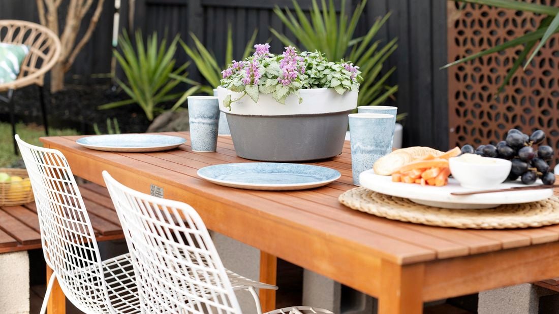 Painted terracotta pot on an outdoor dining table