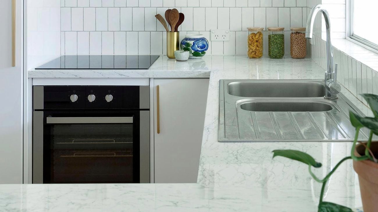 white kitchen with tiled splashback and kitchen utensils