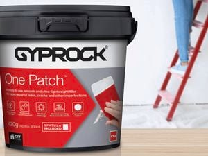Woman on a ladder using Gyprock One Patch to repair a crack high up in a wall