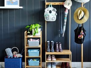 Organised timber shelving rack, with kids boots and shoes and hanging bag and umbrella off hooks. Separate hat stand with hats and small four tier rack with basket organisers.