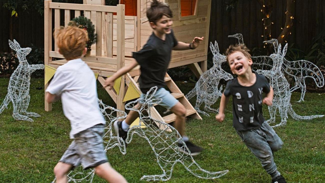 Children running around solar statues in the shape of animals.