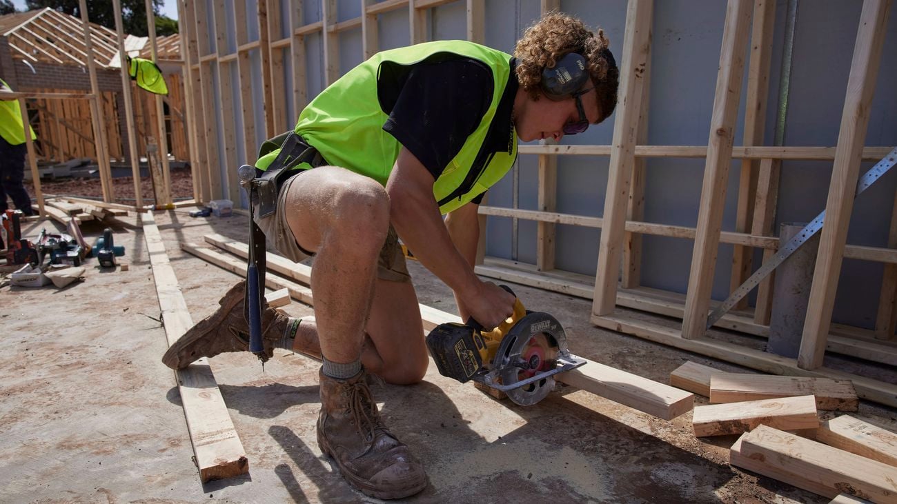 A tradie onsite uses a circular saw wearing hearing and eye protection