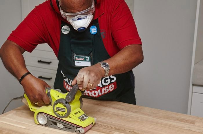 Person using sander on benchtop.