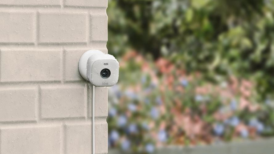 Smart camera on brick wall outside.