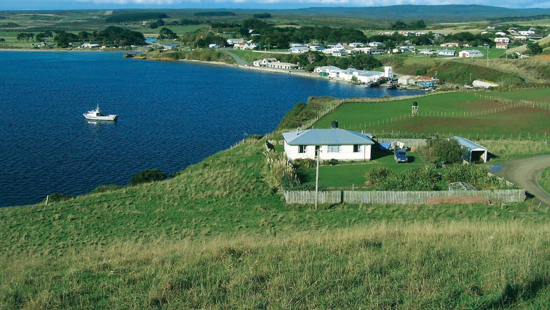An aerial shot of an island with several houses built on it