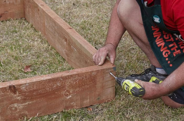 Two sleepers being bolted together as part of a garden bed