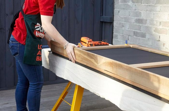 Person attaching shelf to the chalkboard.