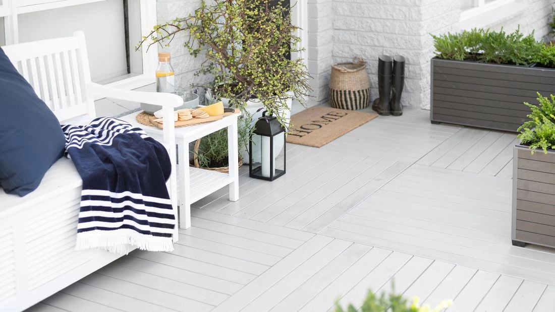 White outdoor decking area with planters and boots.