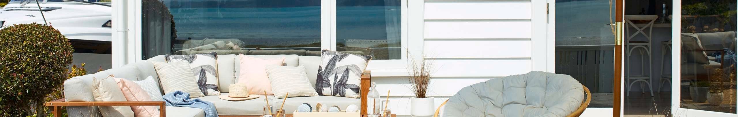 Beach shack with outdoor setting and umbrella on the deck.
