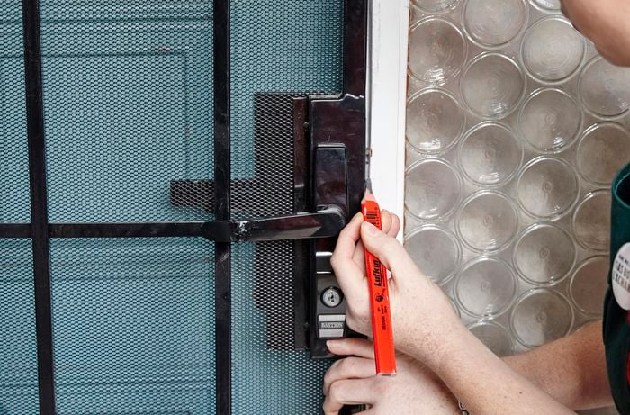The door frame being marked with the position of the striker using a pencil