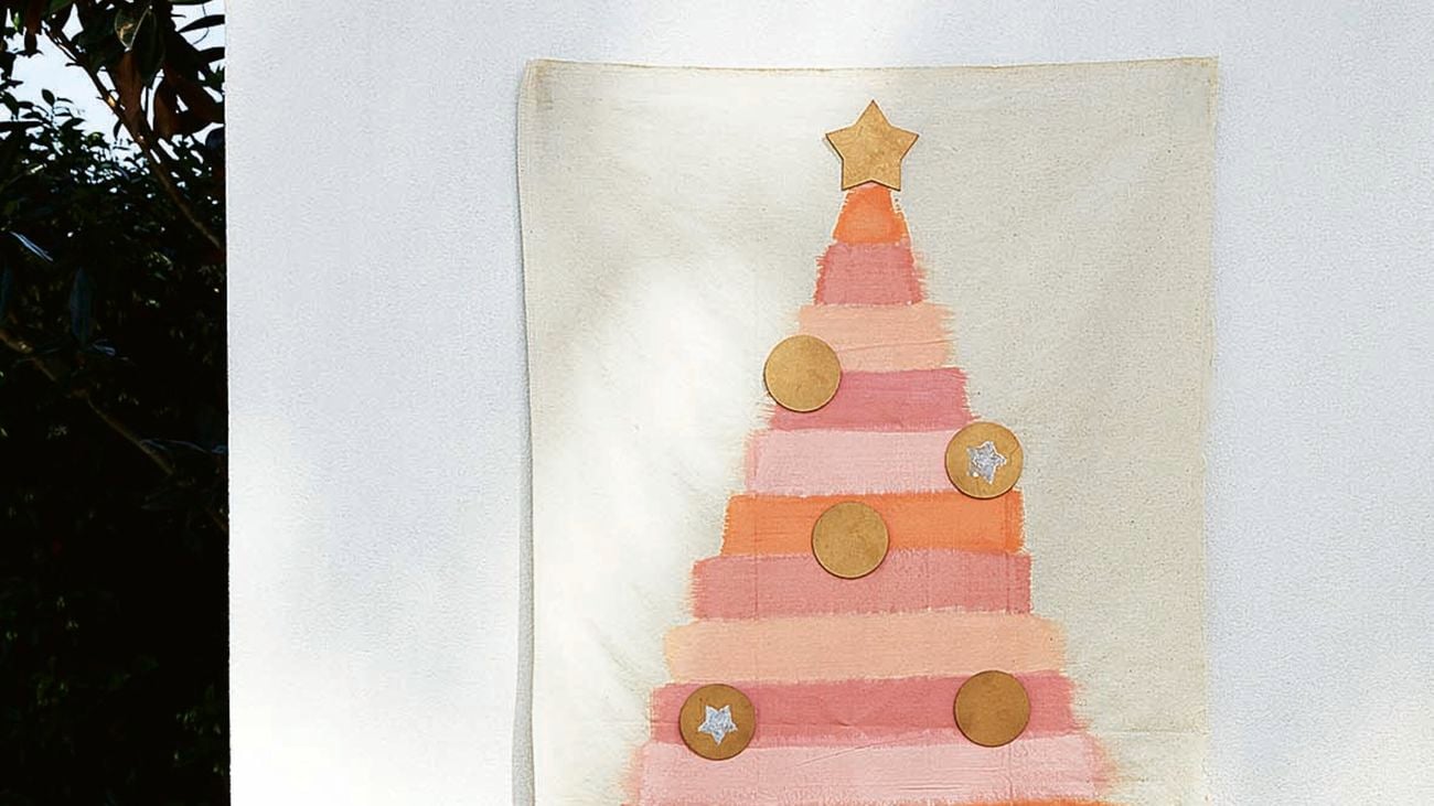 Pink and orange Christmas tree painted on a drop sheet, with wood coasters attached.