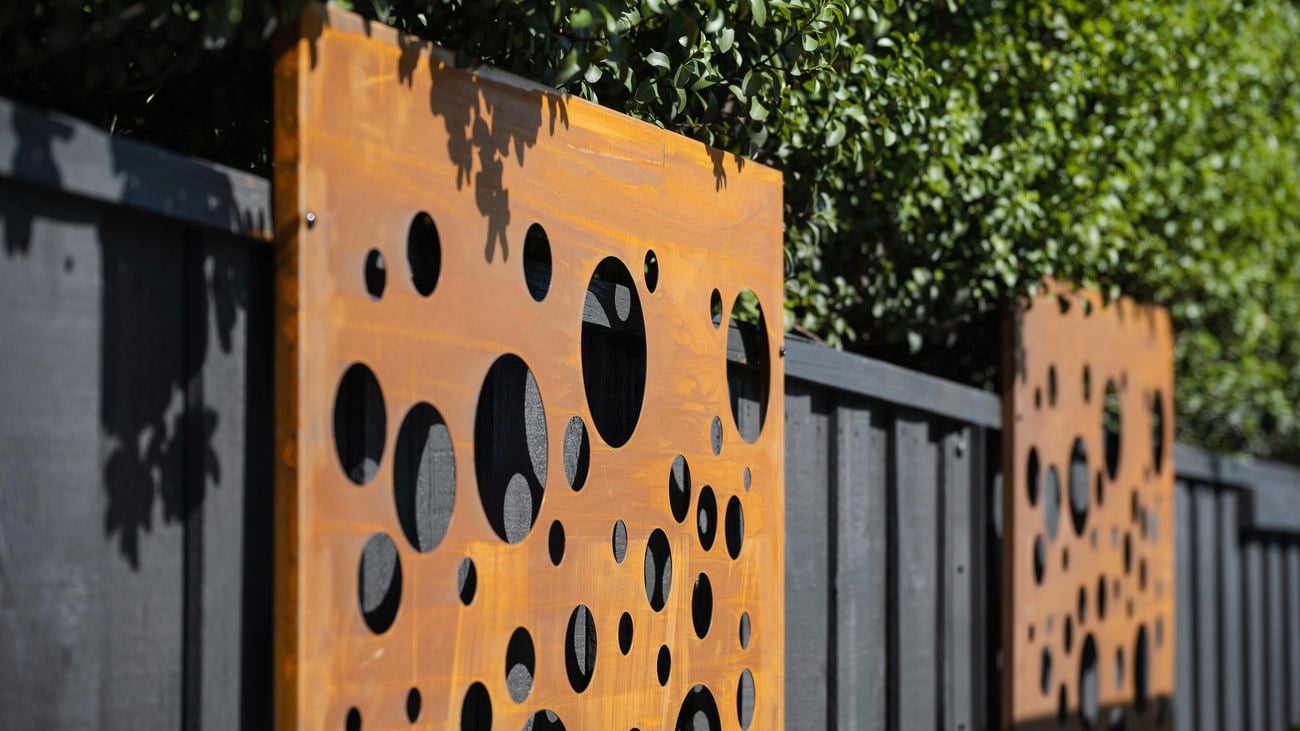Rust coloured panels on a hedge