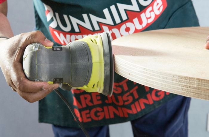 Person sanding edge of circular tabletop