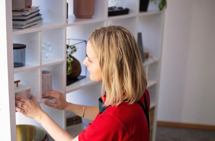Person putting various objects in completed room divider