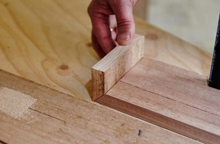 A person joining two lengths of timber at right angles