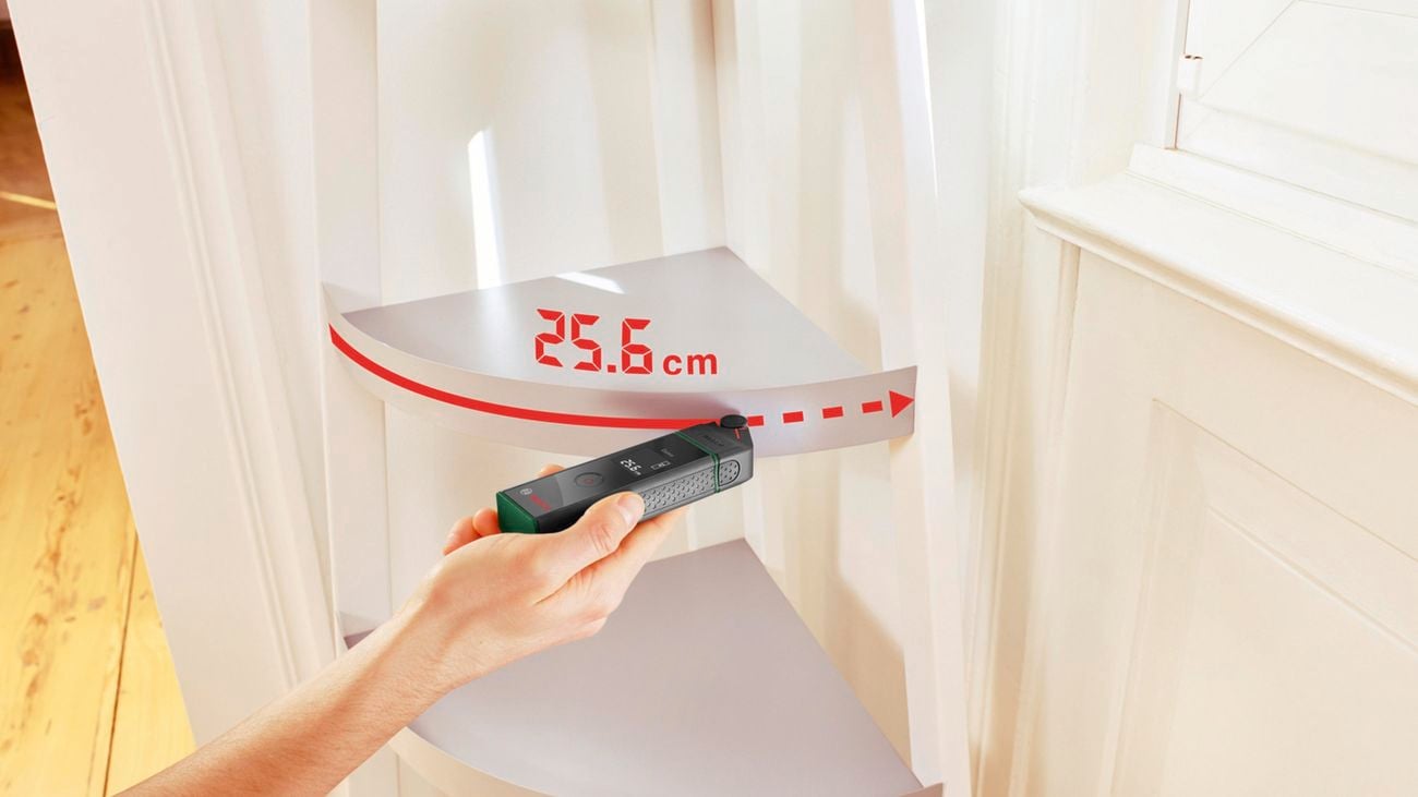 Person using Bosch Zamo Laser Measure Set to measure a curved corner shelf.