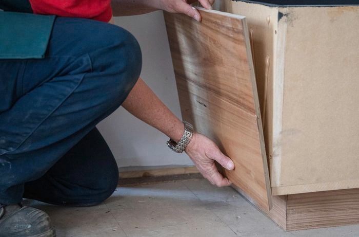 A person attaching the cladding to bench seat.
