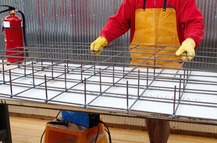 A third sheet of wire mesh laid out over two sheets welded together to make a series of cubes