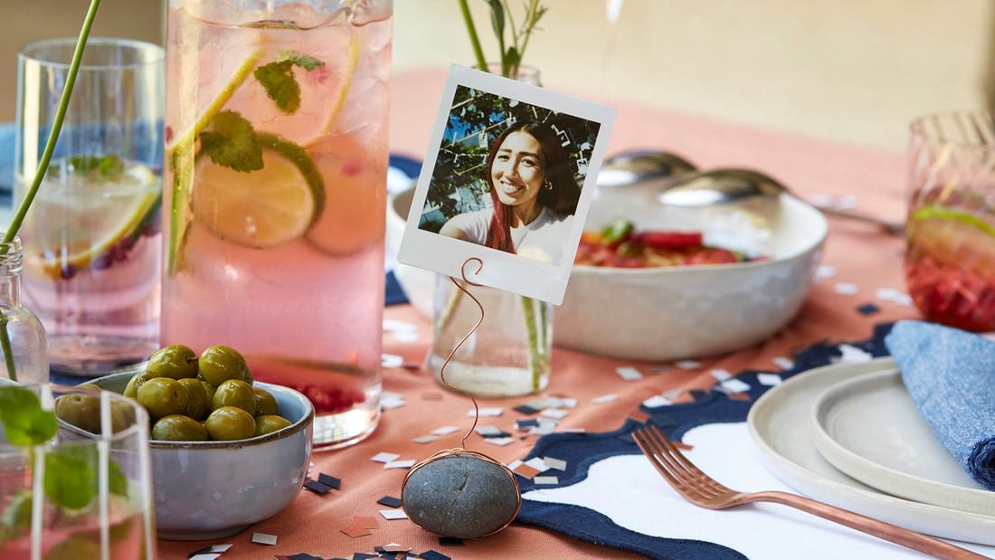 Handmade picture place cards using Polaroid photos displayed on a party table