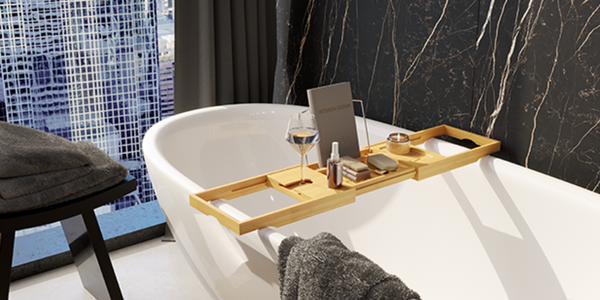 Bathroom with bathtub along with wooden bath caddy, towels and black design wall tiles.