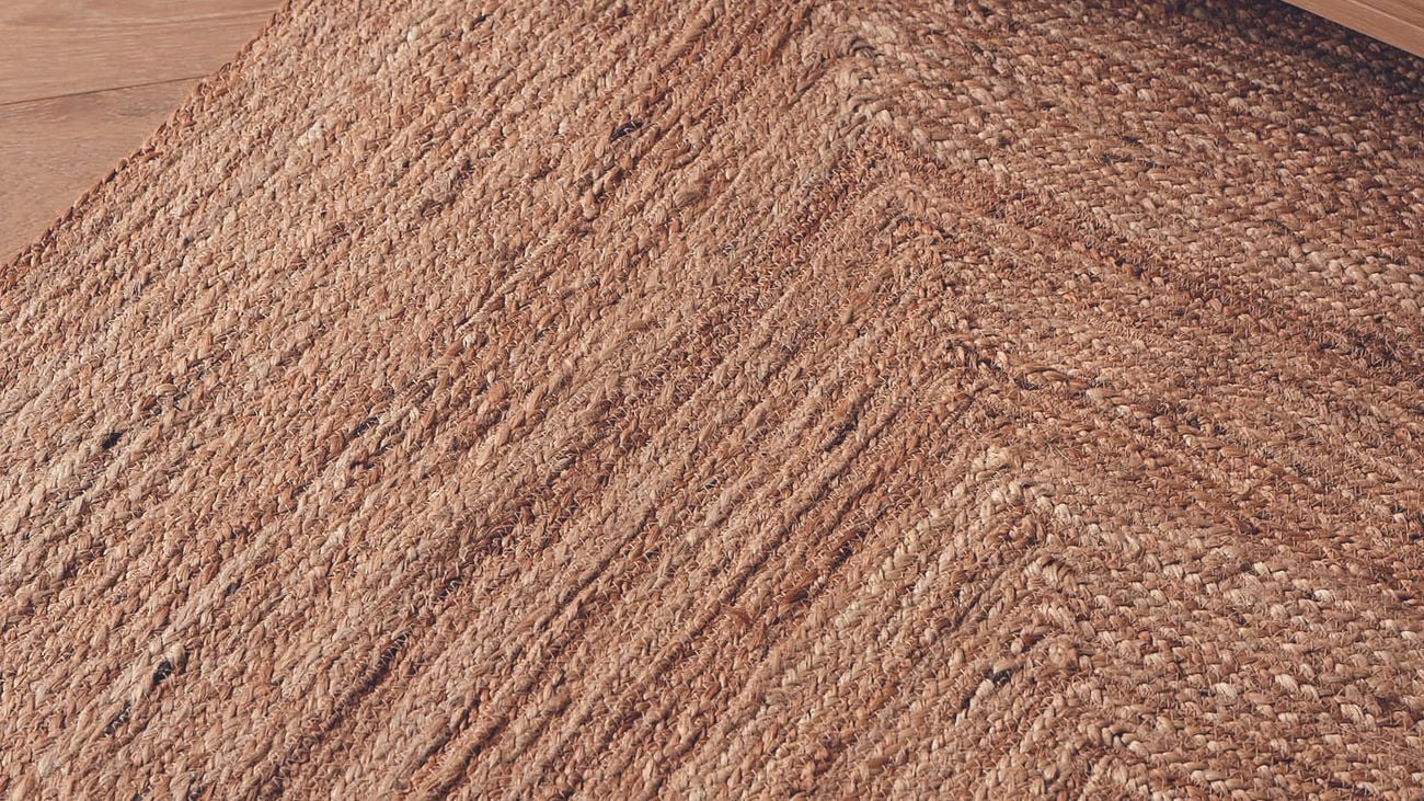 Brown woven rugs placed on a floor with furniture on top