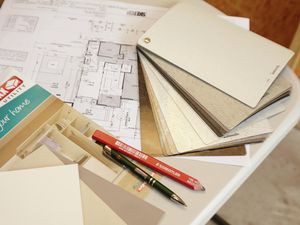 A house plan, colour swatch, pen and pencil on a desk