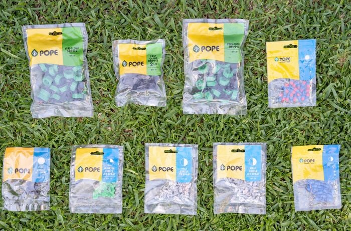 The image shows irrigation system accessories, including various types of drippers and sprayers.