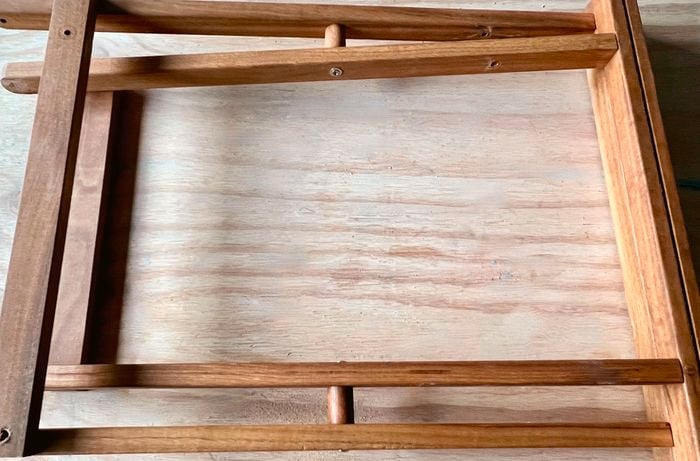 The frame of a foldable chair lying on a wooden surface