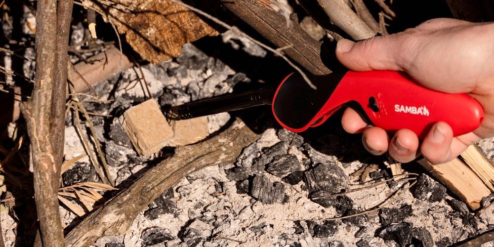 Samba
  Flip Flame Gas Lighter (0255314) lighting Samba Natural Firelighters
  (3170453) at the base of campfire in firepit