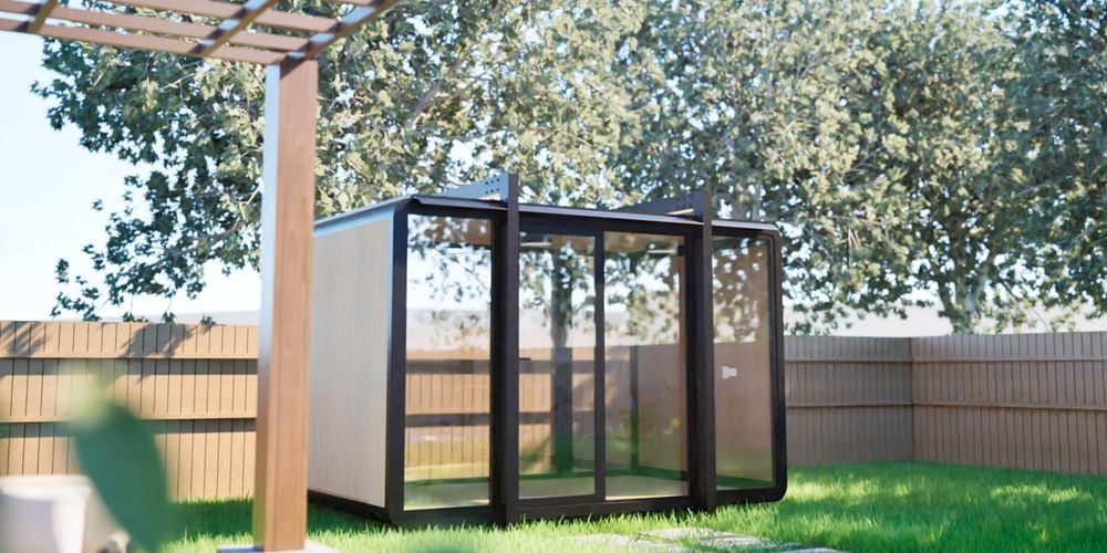 Image of a 4m Elsewhere backyard pod with full-height windows, shown in an Australian summer setting.