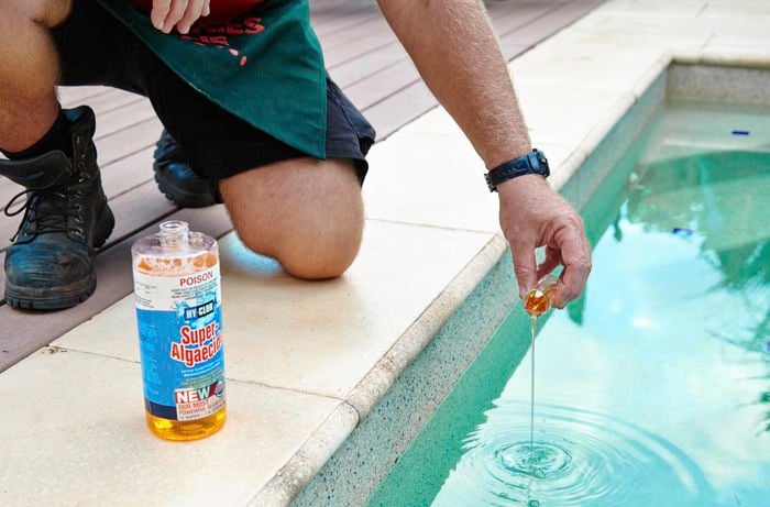 Algaecide being added to a pool