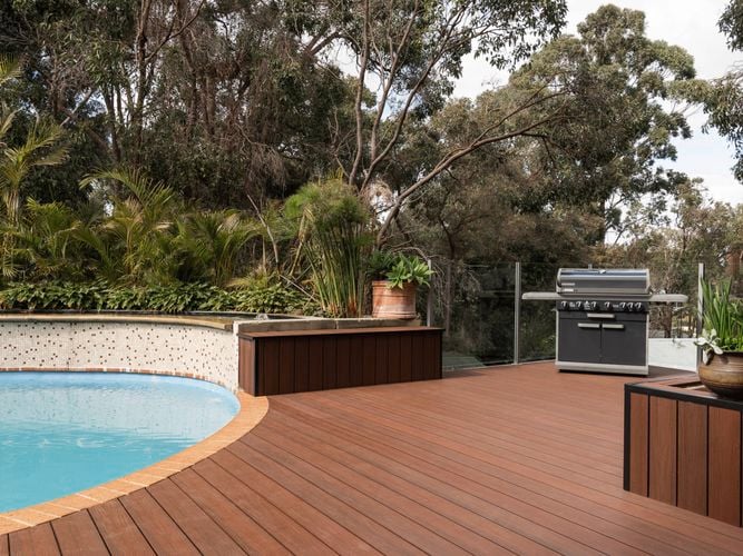 Outdoor area with decking, a pool and a barbecue.