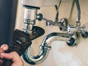 Plumbing fittings behind a bathroom basin