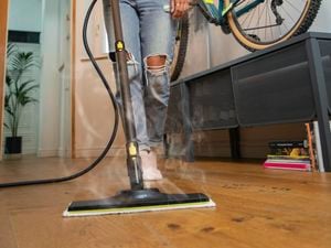 Person using steam cleaner to clean timber flloors